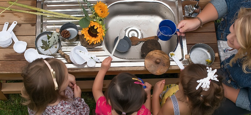 preschool children playing with loose parts in Kinderberry Hill's outdoor classroom